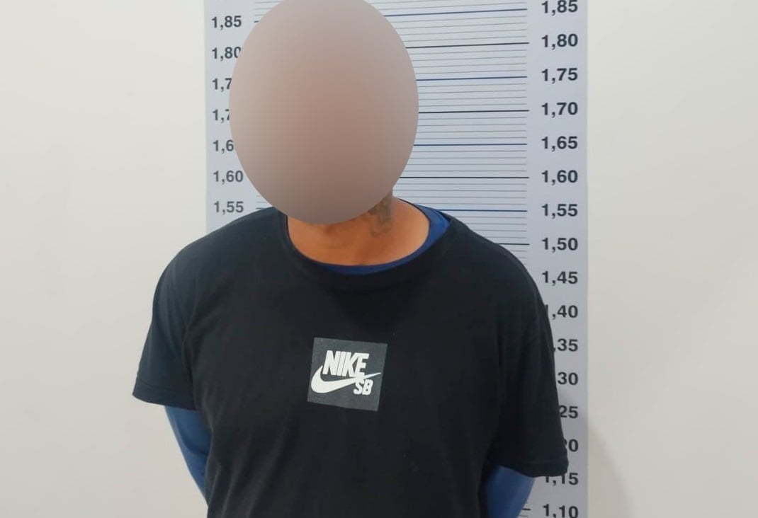 Imagem retrata home preso, com rosto embaçado.