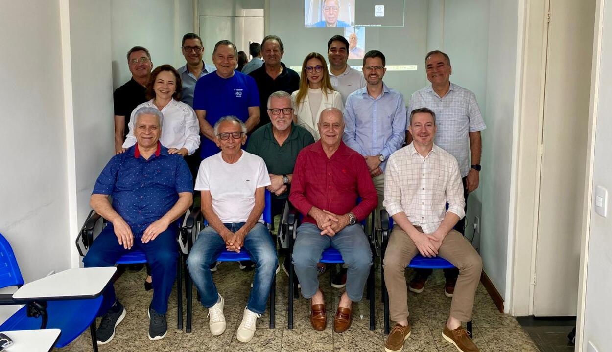 Imagem ilustra posse do Messes. Pessoas em pé e sentadas de frente para a câmera