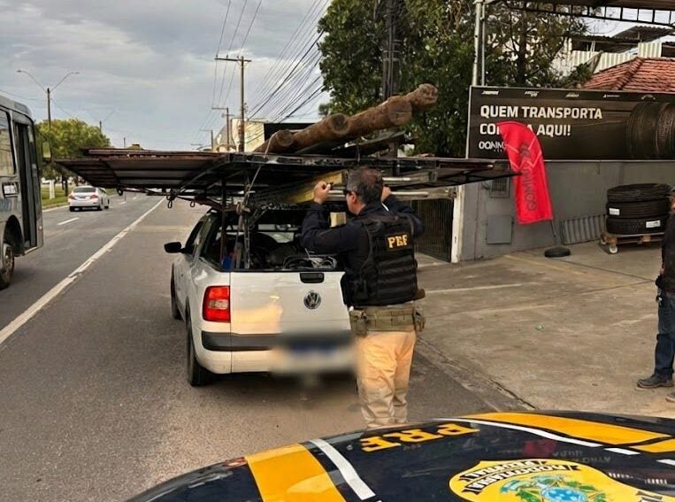Imagem retrata policial fazendo abordagem a veículo.
